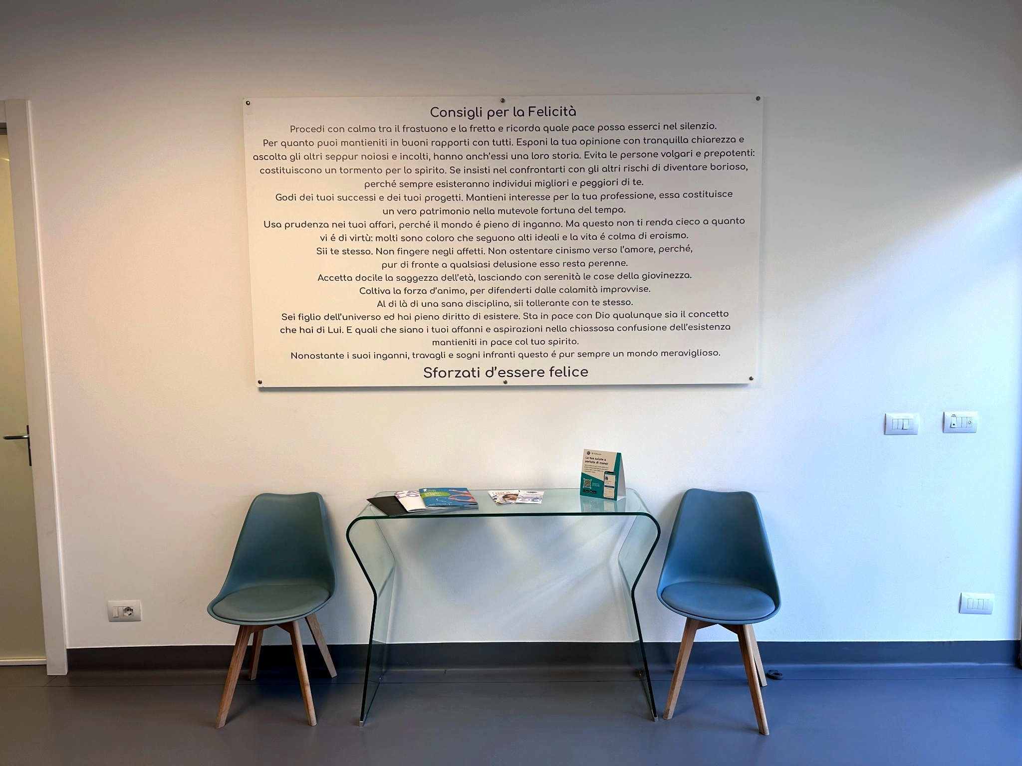 Sala operativa dello studio con frase motivazionale sul sorriso